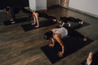 © JAKE JAKAB/ADDICTIVE STOCK - From above barefoot unrecognizable women in sportswear concentrating and doing plank exercise on sports mats on wooden floor against white walls of spacious hall