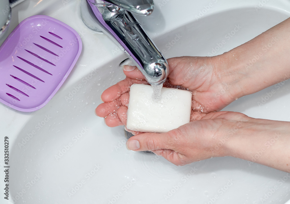 Woman washing hands with soap under the faucet in bathroom. Step by ...
