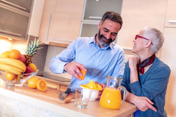 Wall Mural - Couple in the kitchen drink orange juice