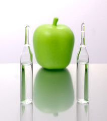 Wall Mural - medical ampoules with an apple on a white background. Natural remedies.