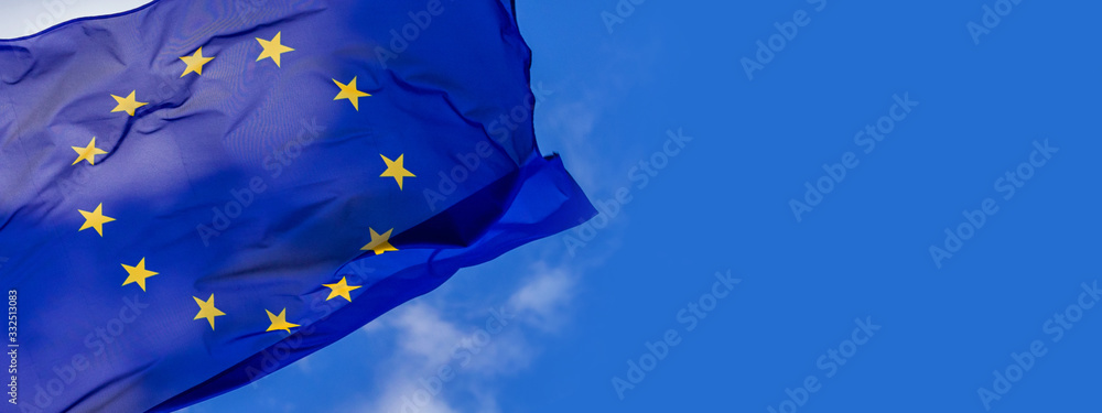Flag of the European Union waving in the wind on flagpole against the sky with clouds on sunny day, banner, close-up - obrazy, fototapety, plakaty 