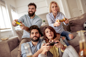 Poster - Smiling friends playing video games at home