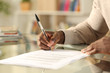 © PheelingsMedia - Black man hands signing document on a desk at home