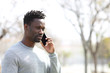 © PheelingsMedia - Serious black man calling on smart phone at park