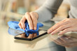 © PheelingsMedia - Woman hands cleaning phone screen at home
