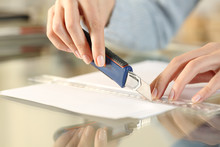 Woman Hands Cutting Paper With Cutter And Ruler