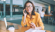 © BullRun - Happy woman speaking on phone in cafe