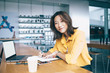 © BullRun - Cheerful teenager writing and looking at camera in electronics store