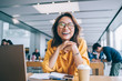 © BullRun - Portrait of excited hipster student in classic glasses for vision protection feeling excited and laughing during free time in university classroom, happy smiling Chinese woman e learning indoors