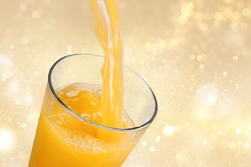 Poster - Orange juice pouring in glass on background