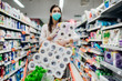 Toilette paper shortage.Woman with hygienic mask shopping for toilette paper supplies due to panic buying and product hoarding during virus epidemic outbreak.Hygiene products deficiency