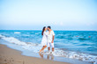 © Yarkovoy - Couple of lovers just married, honeymoon. Elegant and attractive happy family man and woman walking at sea coast. Young wife and husband in love