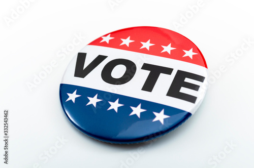 Democracy, presidential election and voting poll concept with red, white and blue vote glossy button pin with stars and stripes isolated on white background with clipping path cutout