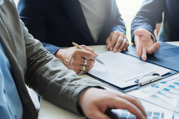 Wall Mural - Signing Contracts. A group of business people sign a joint investment contract.