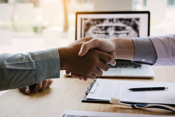 The dentist agreed with the patient by holding shaking hands with confidence.