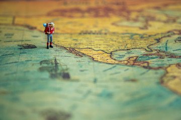 Miniature people: Group of backpacker on vintage world map using as business trip traveler adviser agency or explorer on earth background concept.