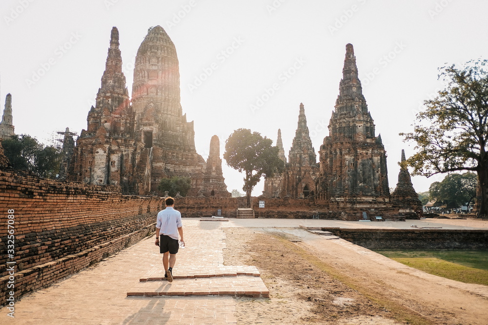 Traveler tourist man walking at Chaiwatthanaram temple of Ayutthaya in the Thailand. ayutthaya historical park, Ayutthaya, Thailand. - obrazy, fototapety, plakaty 