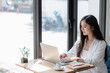 © littlepigpower - young woman using laptop computer while sitting at cafe background, technology and lifestyle. Beautiful young business woman looking at her laptop.