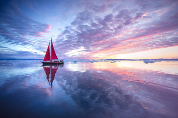 Wall Mural - sail boat with red sails cruising among ice bergs during sunrise. disko bay, greenland.