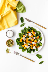 Wall Mural - Light dish for lunch. Salad with pumpkin and basil on white background top-down