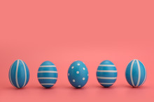 A Row Of Five Blue Decorated Easter Eggs On A Pink Background. Blue Eggs Decorated With White Stripes And Circles. Happy Easter Card With Place For Text. Copy Space. 