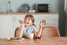 Cute Little Girl Eating Chocolate In Kitchen