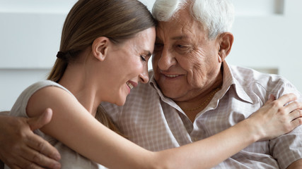 Wall Mural - loving adult daughter and older father touching foreheads close up, family enjoying tender moment, s
