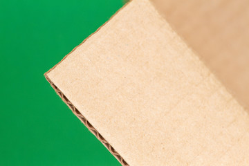 Wall Mural - Close up of open cardboard box edge on green background