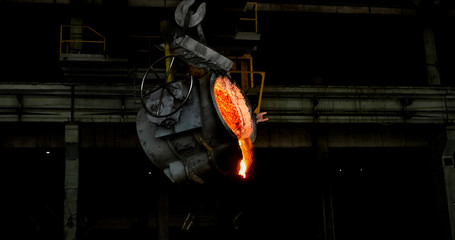 Wall Mural - Smelting orange metal in a metallurgical plant. Liquid iron from the ladle