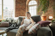 © master1305 - Calling clients. Caucasian woman, freelancer during the work in home office while quarantine. Young businesswoman at home, self isolated. Using gadgets. Remote work, coronavirus spread prevention.
