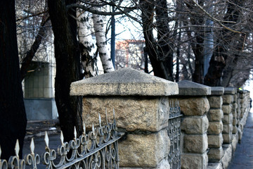 Old fences fences with stone pillars and iron artistic bars