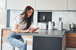 © standret - Young beautiful brunette in casual clothes sits in kitchen with fresh drink at morning time