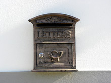 A Retro Looking Gray Mailbox, Or Letterbox, Affixed To The Exterior White     Wall     