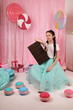 girls-models have fun at a birthday party in a beautiful, delicious, pink candy interior, the concept of themed children's parties, holidays, participation in competitions.