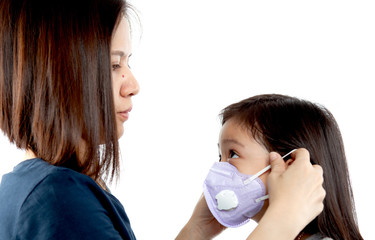 Mom and Asian little child girl is wearing medical face masks to protect themselves from Covi19 virus