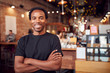 Portrait Of Male Coffee Shop Owner Standing By Counter