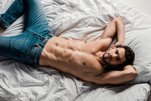 Top View Of Handsome Shirtless Sexy Man Lying On Bed Isolated On Grey