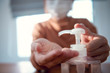 © oatawa - Corona virus protection, Closeup cleaning her hands with sanitizer gels, Woman in quarantine for coronavirus wearing protective mask, Working from home.
