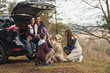 © standret - Happy family have fun with their dog near modern car outdoors in forest