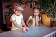 © Maria - Happy kids playing at board game memo in domestic interior, family values actually
