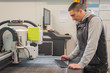 © guruXOX - Technician works on large CNC computer numerical control cutting machine