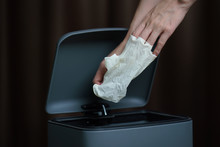 Hand Putting Used Dirty Surgical Glove To  A Garbage Bin. Mask Protect Dust And Corona Virus In Trash.