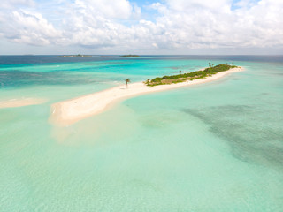 Picture perfect beach and turquoise lagoon on small tropical island on Maldives.