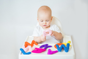 Cute baby boy playing with letters of english alphabet. Early development concept