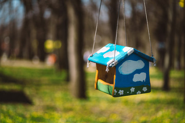 Wall Mural - Closeup photo of bird feeder in park or forest in sun light captured by early spring.