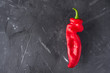 Trendy Ugly organic red pepper a black background. Funny, unnormal vegetable or food waste concept. Horizontal orientation. Ugly food concept, Ugly shaped organic vegetables.