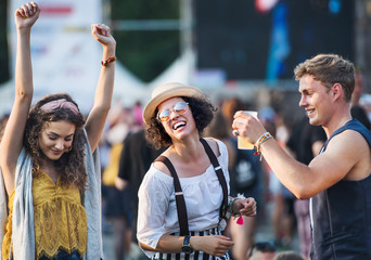 Group of young friends at summer festival, having good time.