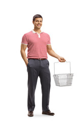 Sticker - Young man smiling and holding an empty shopping basket