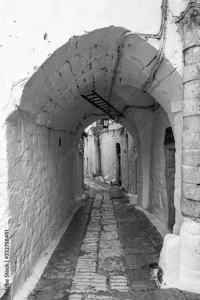 Antigua calle medieval italiana con arco en blanco y negro - obrazy, fototapety, plakaty 