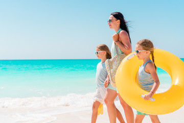 Beautiful mother and her adorable little daughter at beach